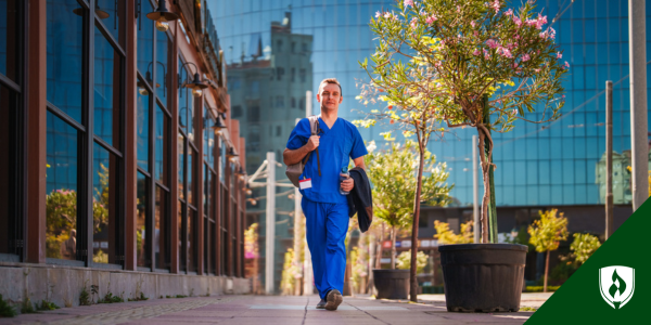 A nurse walks confidently down a city street in spring