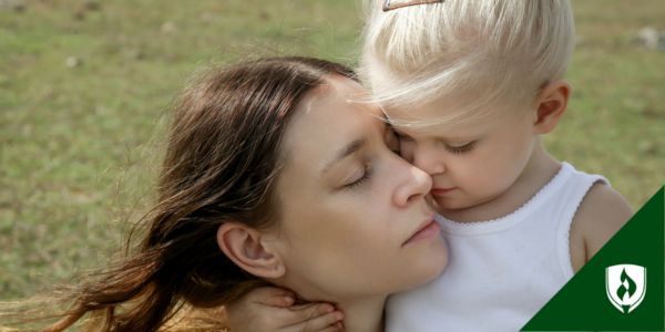 A young child hugs her caregiver outside