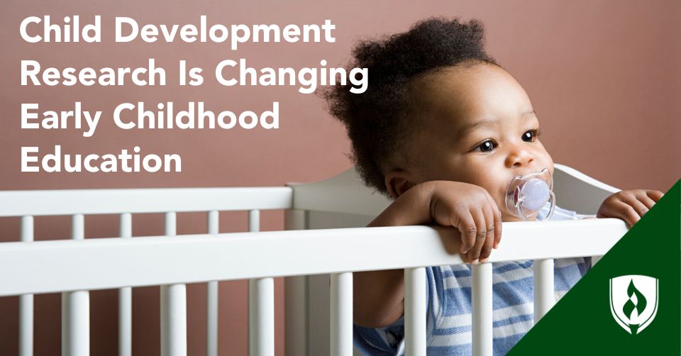 child development research header A very adorable toddler holds onto the side of their crib
